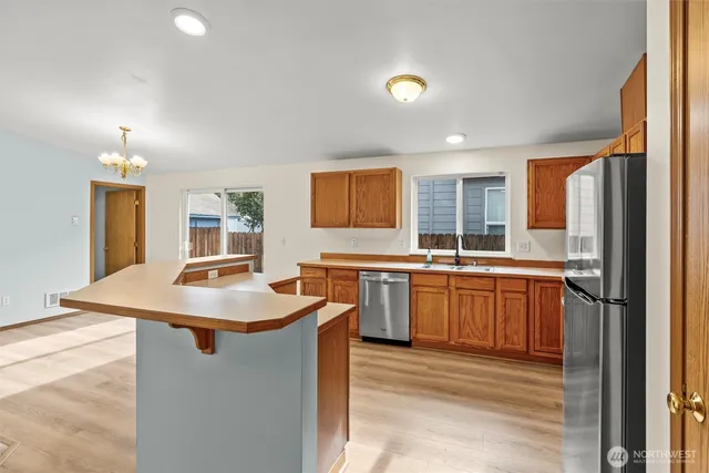 a kitchen with sink refrigerator and cabinets