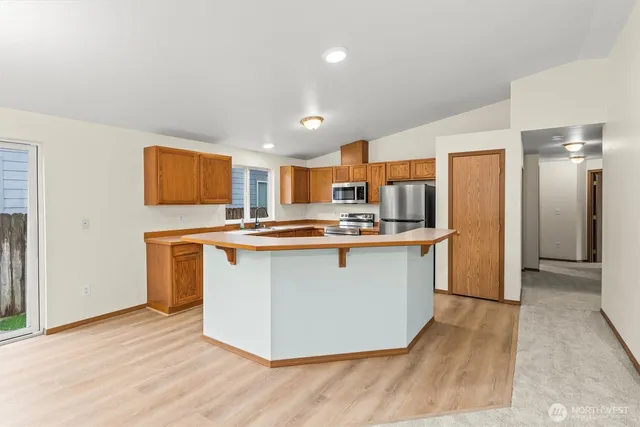a kitchen with stainless steel appliances granite countertop a refrigerator a stove top oven a sink and dishwasher