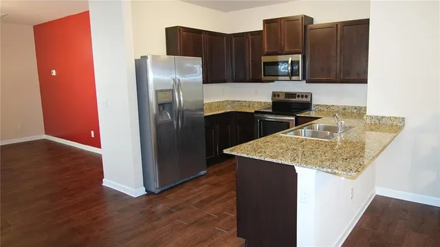 a kitchen with a sink refrigerator and microwave