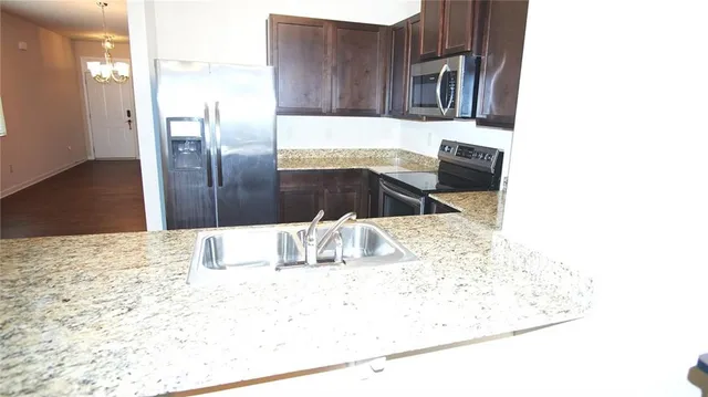a kitchen with stainless steel appliances kitchen island granite countertop a refrigerator and a stove