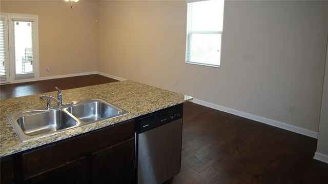 a kitchen with granite countertop a refrigerator and a stove top oven