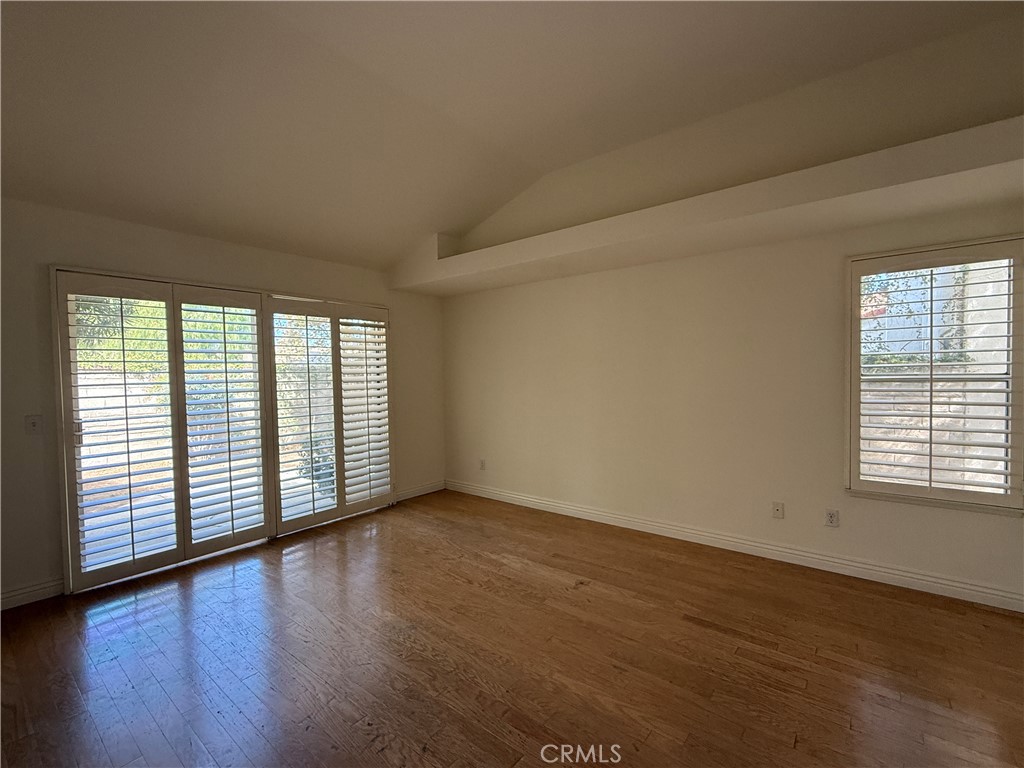 24315 Taranto Avenue Valencia, CA 91355 - Photo 11 of 21 a view of an empty room with wooden floor and a window