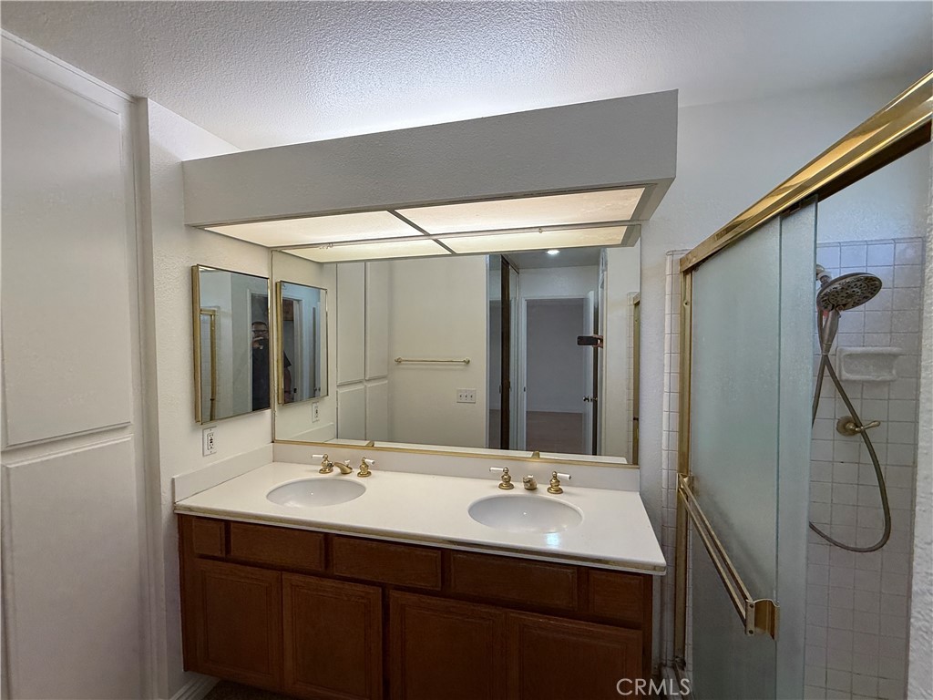 24315 Taranto Avenue Valencia, CA 91355 - Photo 14 of 21 a bathroom with a double vanity sink and mirror