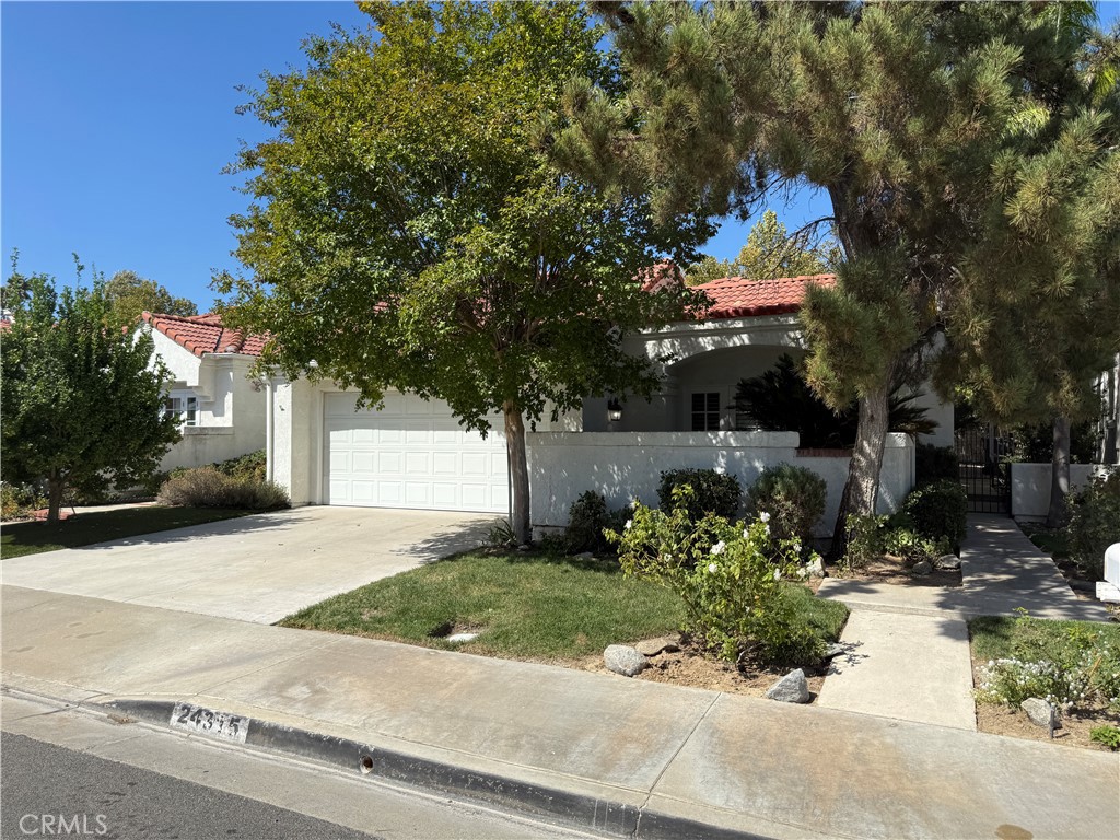 24315 Taranto Avenue Valencia, CA 91355 - Photo 20 of 21 a front view of a house with a yard and a tree
