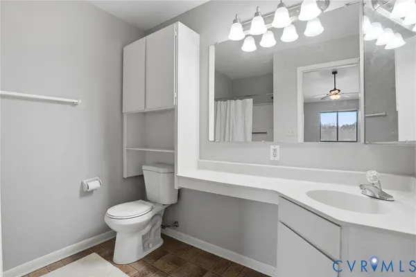 a bathroom with a sink vanity mirror and toilet