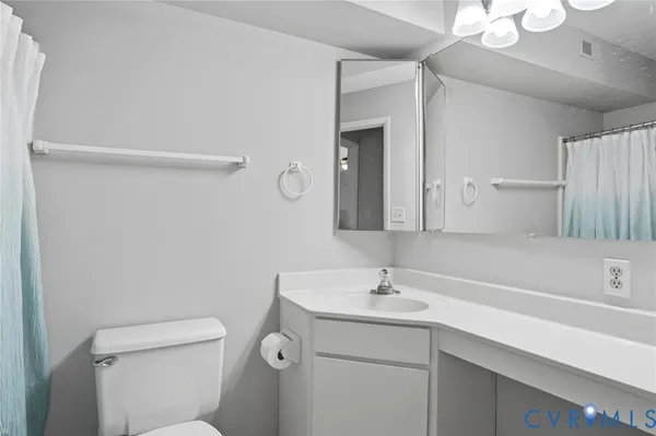 a bathroom with a sink mirror vanity and toilet