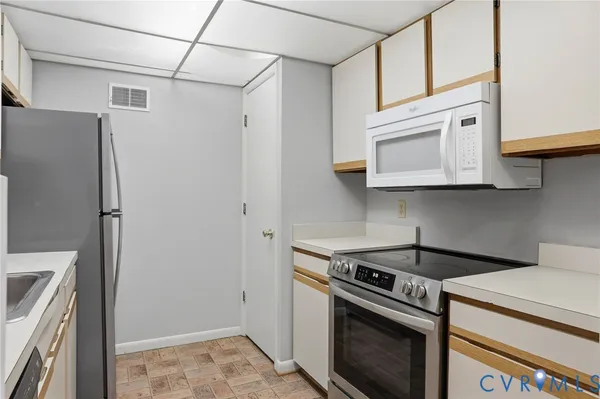 a kitchen with stainless steel appliances white cabinets and a stove top oven