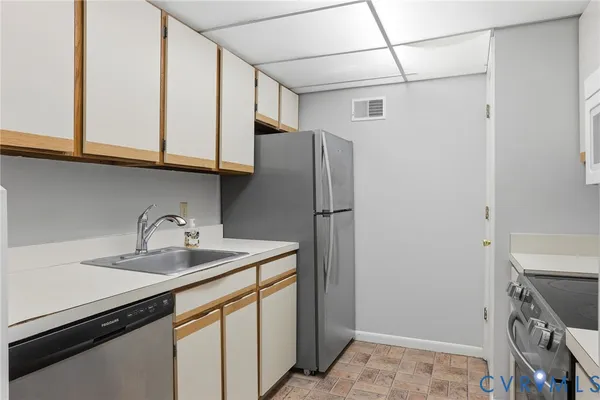 a kitchen with stainless steel appliances granite countertop a refrigerator and a sink