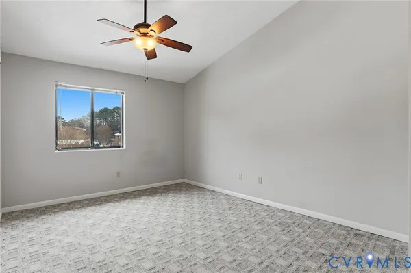 an empty room with a window and a fan