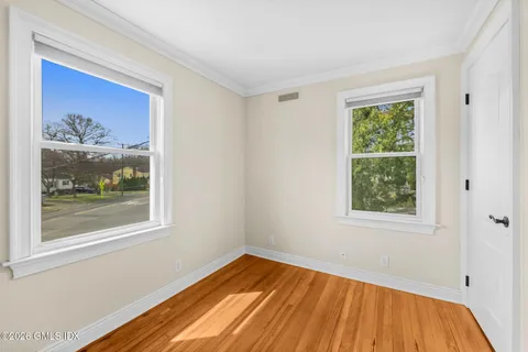 a view of empty room with window and wooden floor