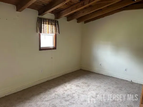 a view of an empty room with a fireplace and a window