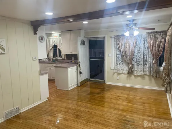 a view of a kitchen with kitchen island a sink stainless steel appliances and cabinets