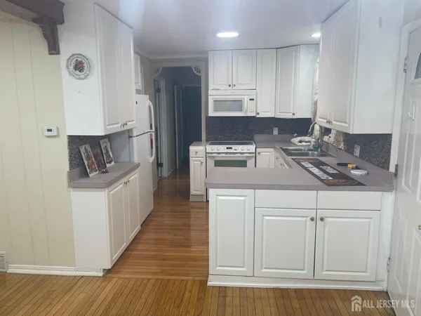 a kitchen with white cabinets and refrigerator