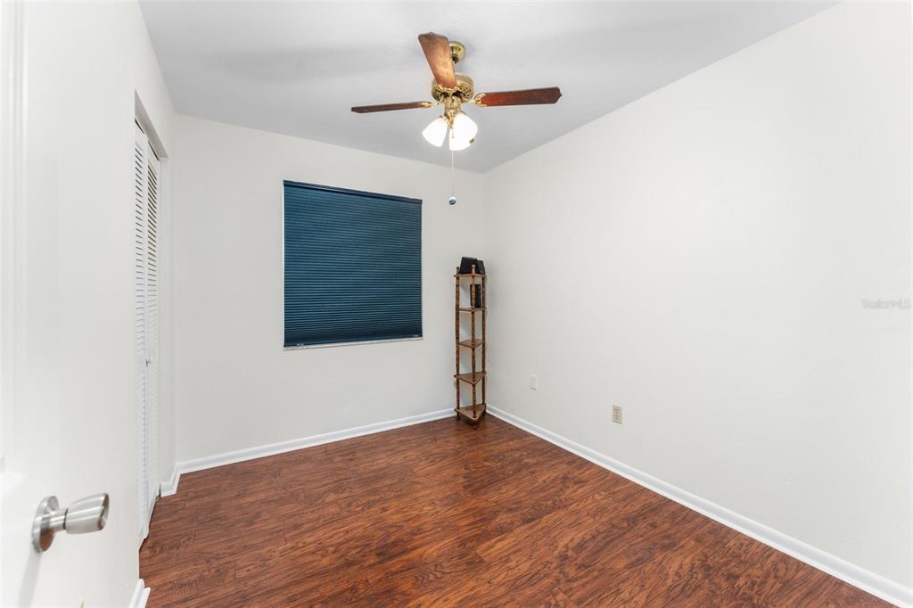 2026 Southwest 73rd Street Gainesville, FL 32607 - Photo 12 of 20 a view of a room with wooden floor and a ceiling fan