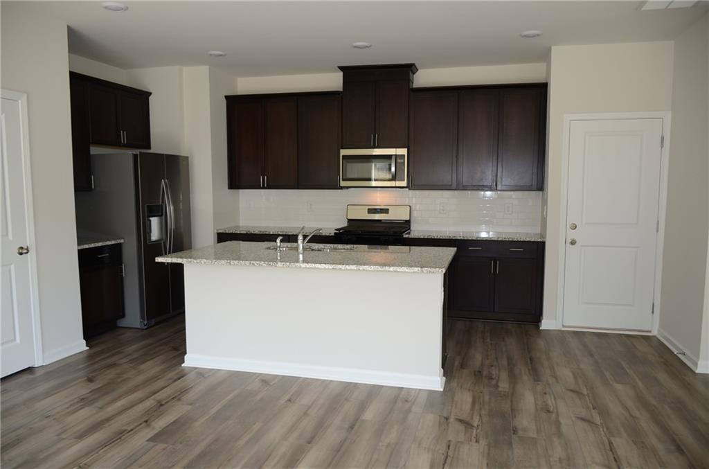 226 Wells Circle Canton, GA 30114 - Photo 8 of 27 a kitchen with a sink a microwave a refrigerator and wooden floor