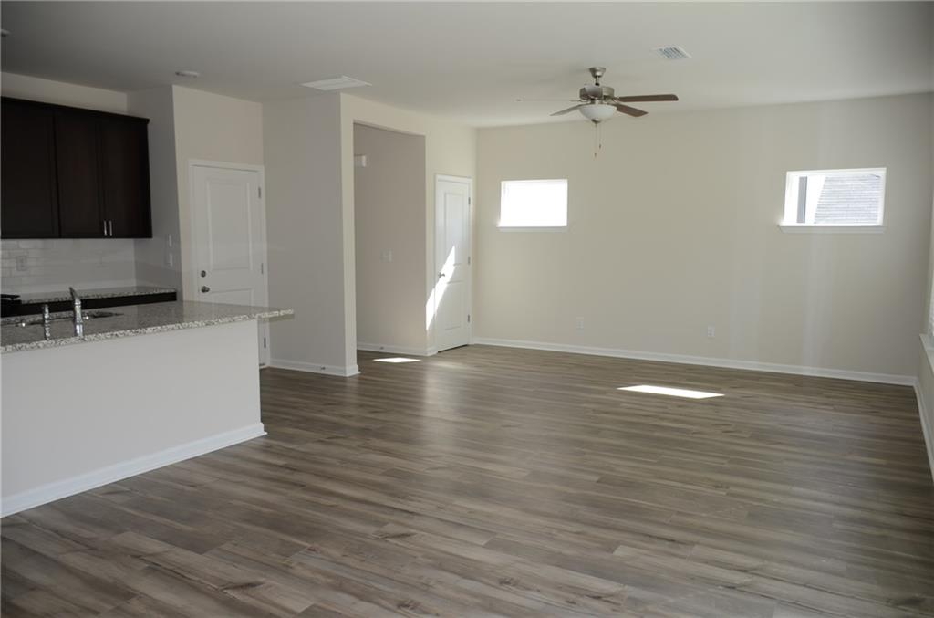 226 Wells Circle Canton, GA 30114 - Photo 10 of 27 a view of a livingroom with wooden floor and a ceiling fan