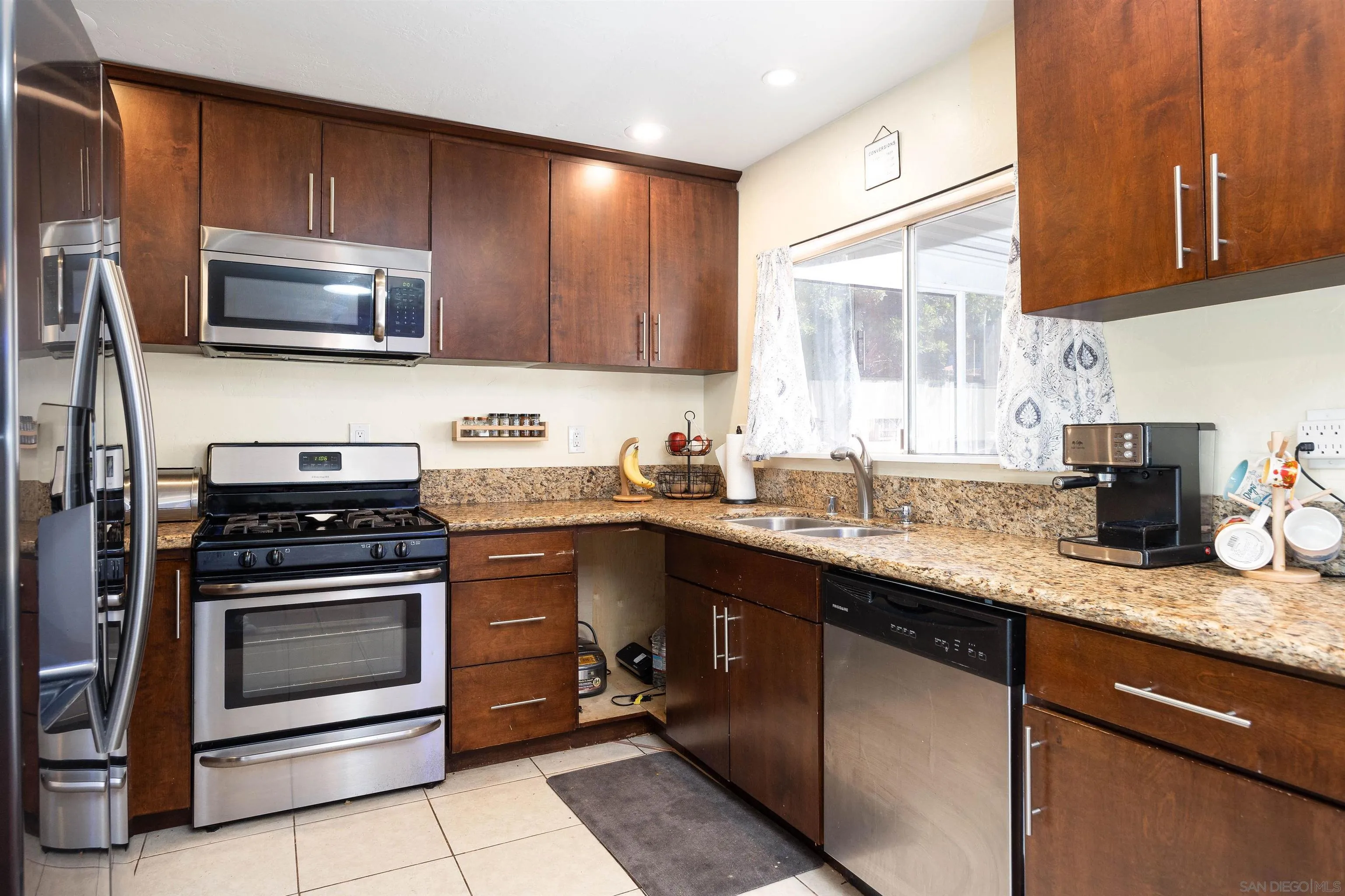 10203 Settle Road Santee, CA 92071 - Photo 8 of 33 a kitchen with granite countertop a sink stove and microwave