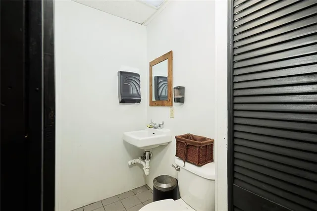 a bathroom with a toilet a sink and mirror