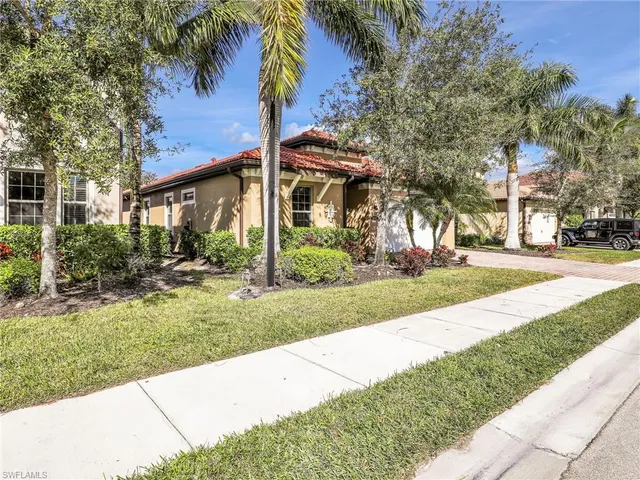 a view of a house with a yard and palm trees