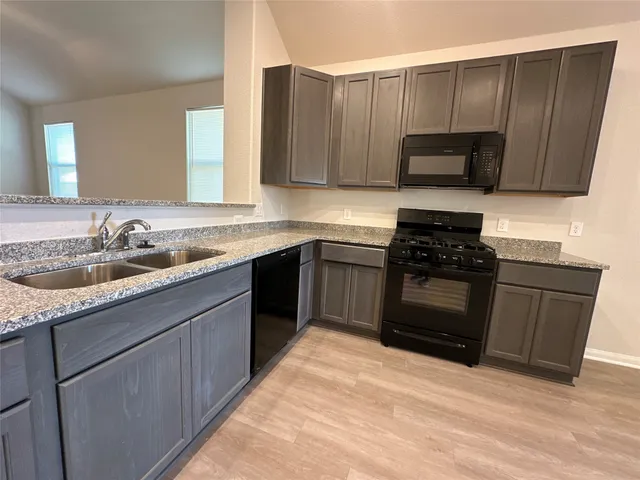 a kitchen with stainless steel appliances granite countertop a sink stove and microwave