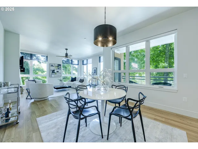 a view of a dining room and livingroom with furniture wooden floor a chandelier