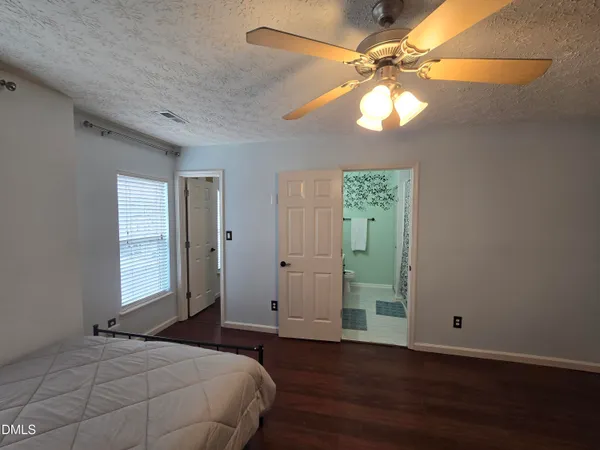 a bathroom with a granite countertop sink a toilet and shower curtain