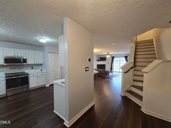 a kitchen with a refrigerator and a stove top oven