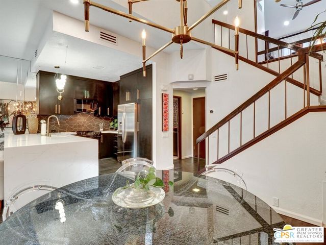 a kitchen with stainless steel appliances kitchen island granite countertop a table chairs stove and living room view