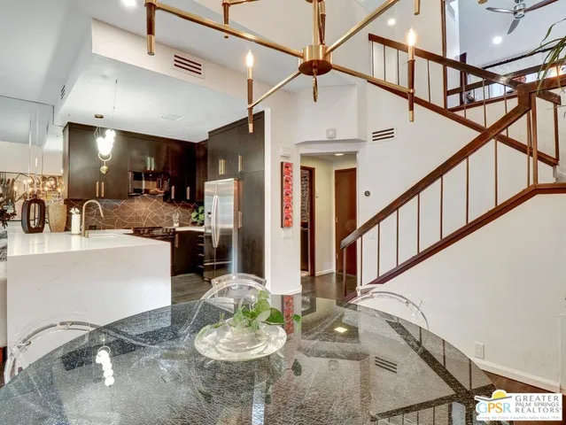 a kitchen with stainless steel appliances kitchen island granite countertop a table chairs stove and living room view