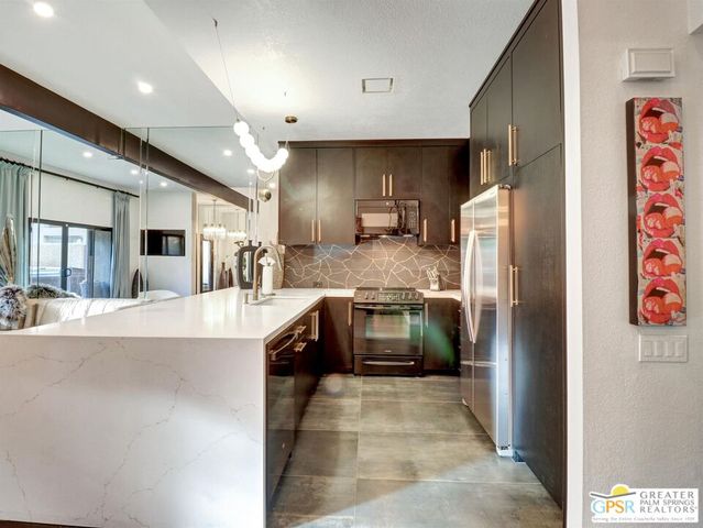 a large kitchen with a stove a refrigerator and a sink