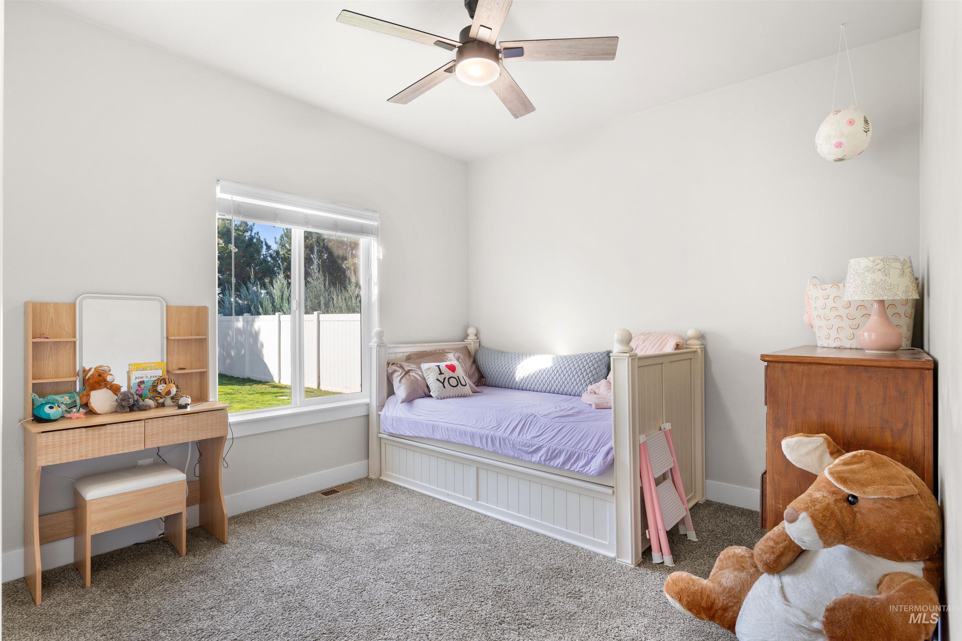 2958 Sunlight Road Twin Falls, ID 83301 - Photo 28 of 40 Wall-to-wall carpeting with light-toned walls, a ceiling fan with integrated lighting, and a large window with white framing