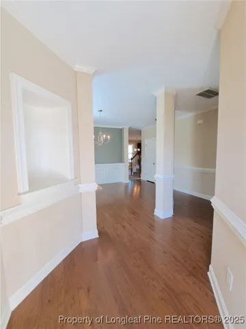 a view of empty room with wooden floor