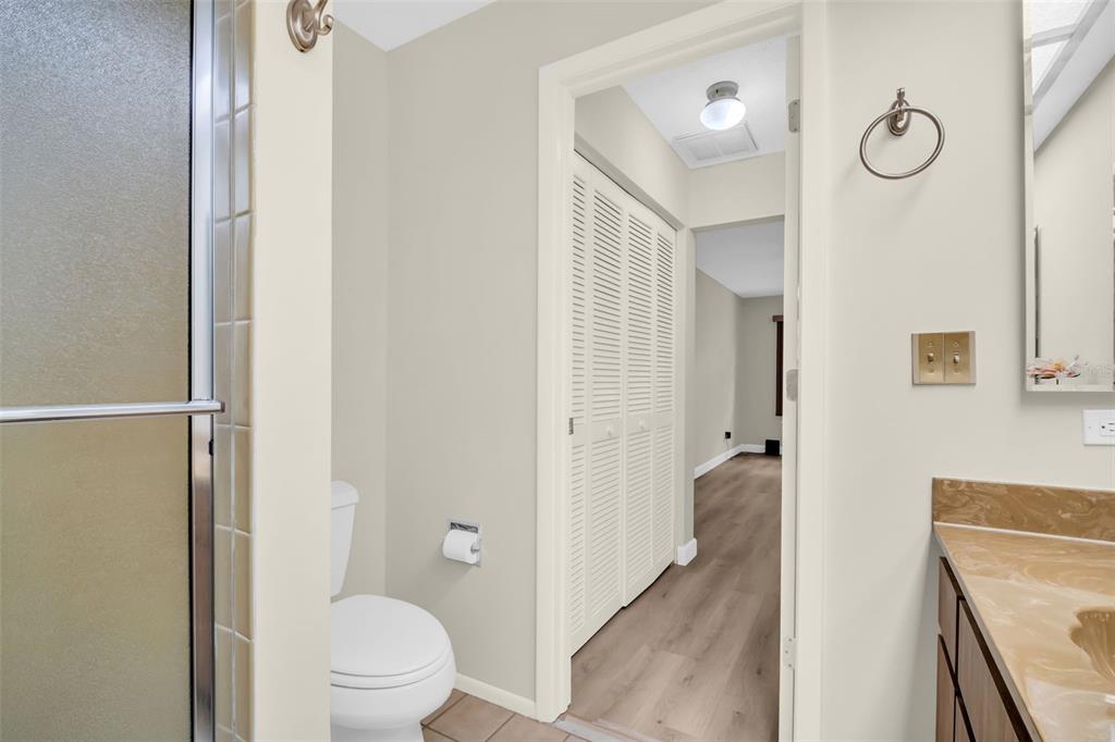 899 Cleland Court, Unit A Palm Harbor, FL 34684 - Photo 28 of 51 a bathroom with a granite countertop sink a toilet and a shower