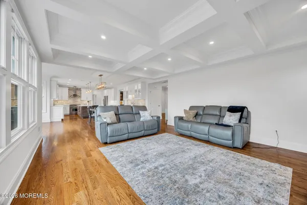 a bedroom with a bed a dresser and a chandelier