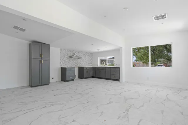 an empty room with windows and cabinet