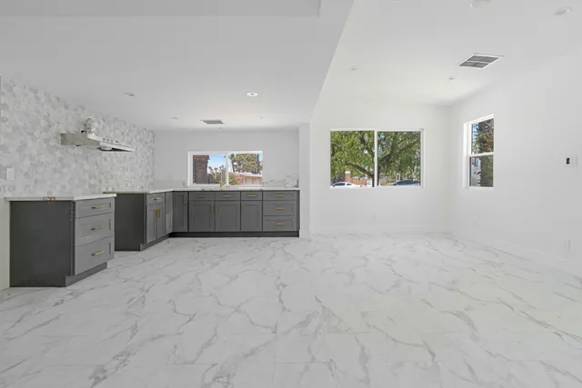 a room with a granite countertop sink and cabinets