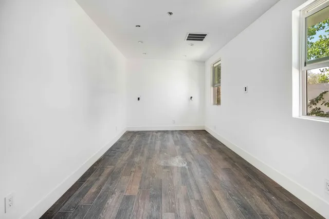 a view of a room with wooden floor and white walls