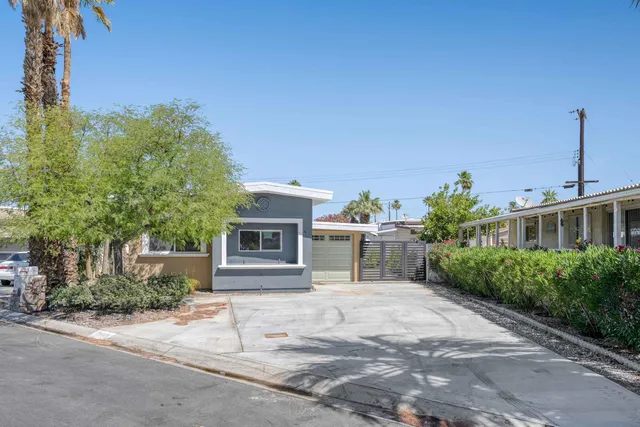 a view of a house with backyard and sitting area