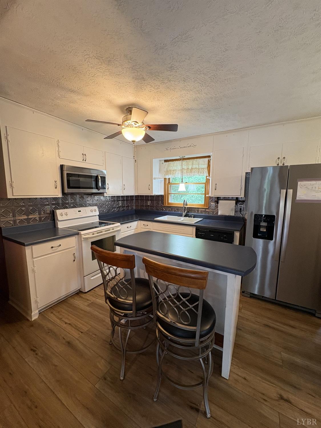1796 Owens Mill Road Gretna, VA 24557 - Photo 5 of 20 a kitchen with kitchen island a dining table chairs and refrigerator