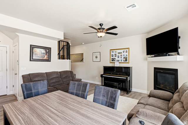 668 East Fiddlers Canyon Road, Unit 6 Cedar City, UT 84721 - Photo 6 of 36 Open-concept living space featuring wood-finish flooring, a contemporary ceiling fan, and a built-in fireplace with a white floating mantel