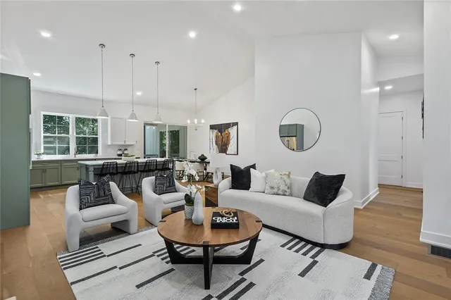 a living room with furniture kitchen view and a large window