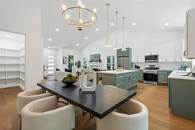 a kitchen with a dining table chairs sink and microwave