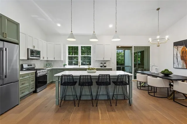 a kitchen with a table chairs microwave and cabinets