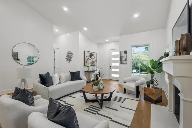 a living room with furniture fireplace and a large window