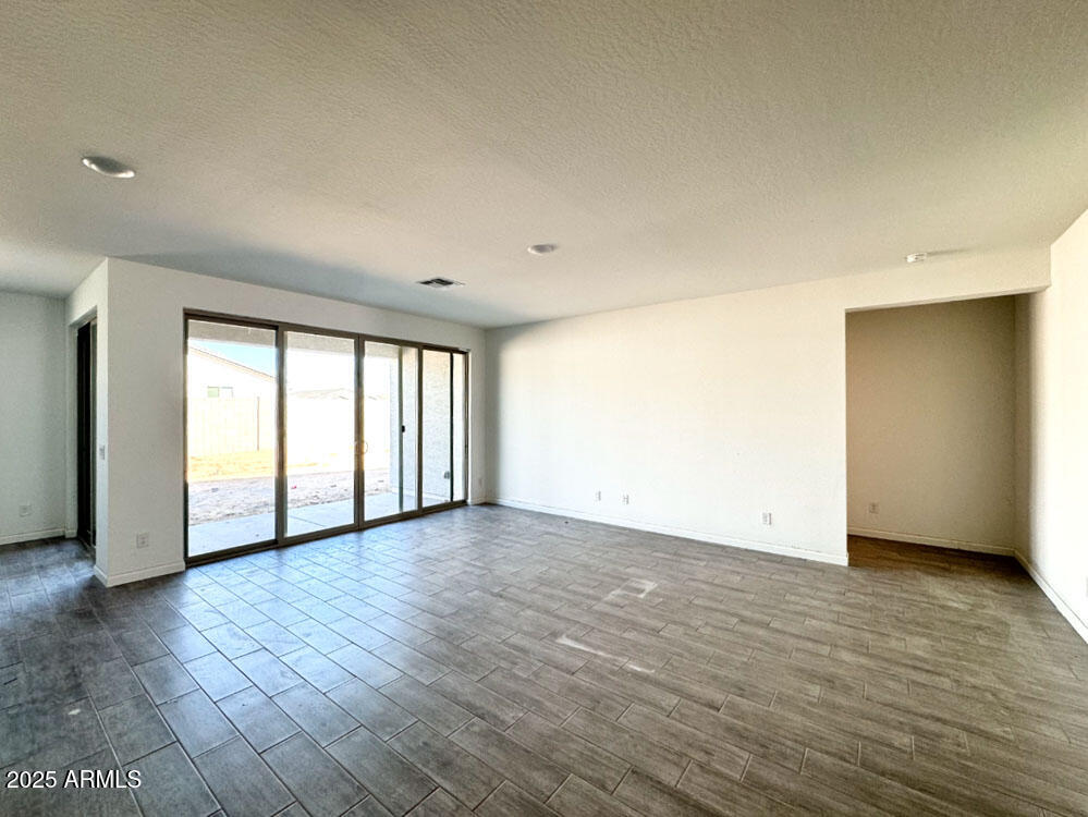 15714 West Brown Street Waddell, AZ 85355 - Photo 13 of 36 a view of an empty room with wooden floor and a window