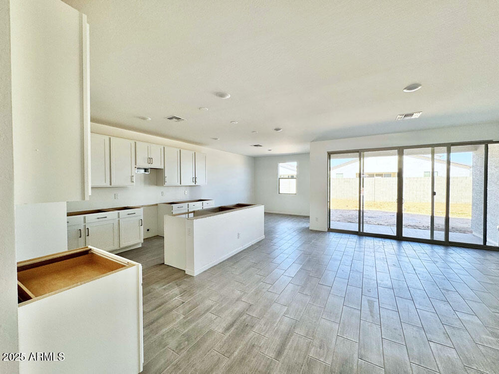 15714 West Brown Street Waddell, AZ 85355 - Photo 8 of 36 a large kitchen with stainless steel appliances granite countertop a stove a sink and white cabinets with wooden floor