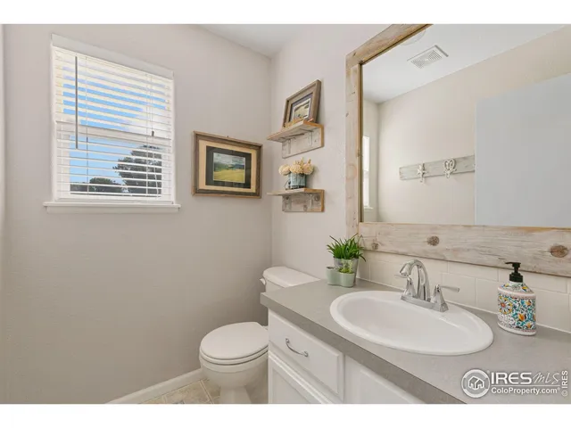 a bathroom with a granite countertop toilet sink and mirror