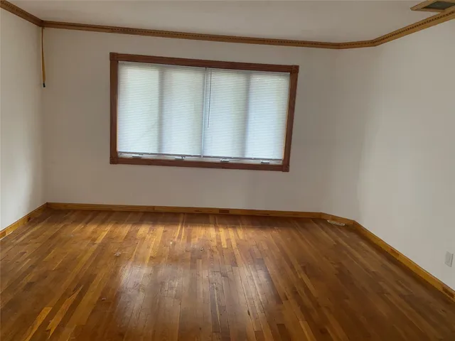 a view of a small space with wooden floor and a window