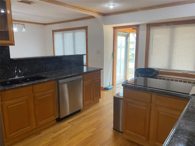 a kitchen with granite countertop wooden cabinets and a wooden floor
