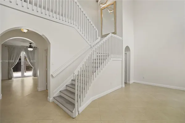 a view of staircase with railing and white walls